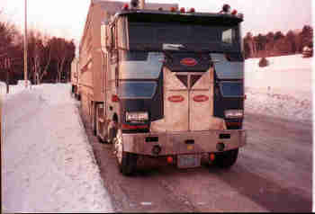 Double deck cattle trailer with horses on the top and bottom decks.