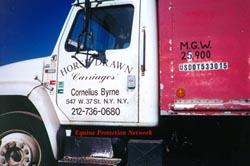 NYC carriage company in parking lot of New Holland Sales Stables. Close up of driver's side door with address.